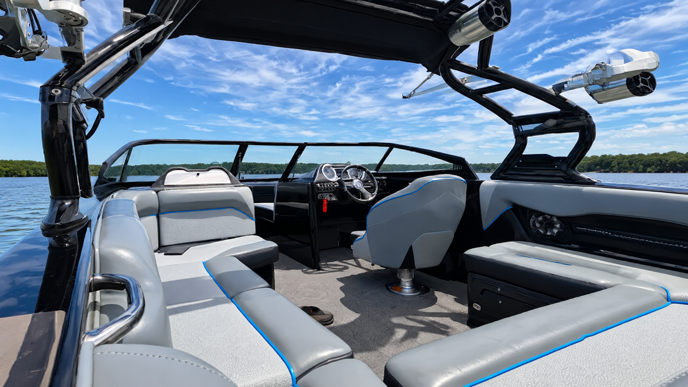 Boat interior with gray seats and black wake tower under a blue sky