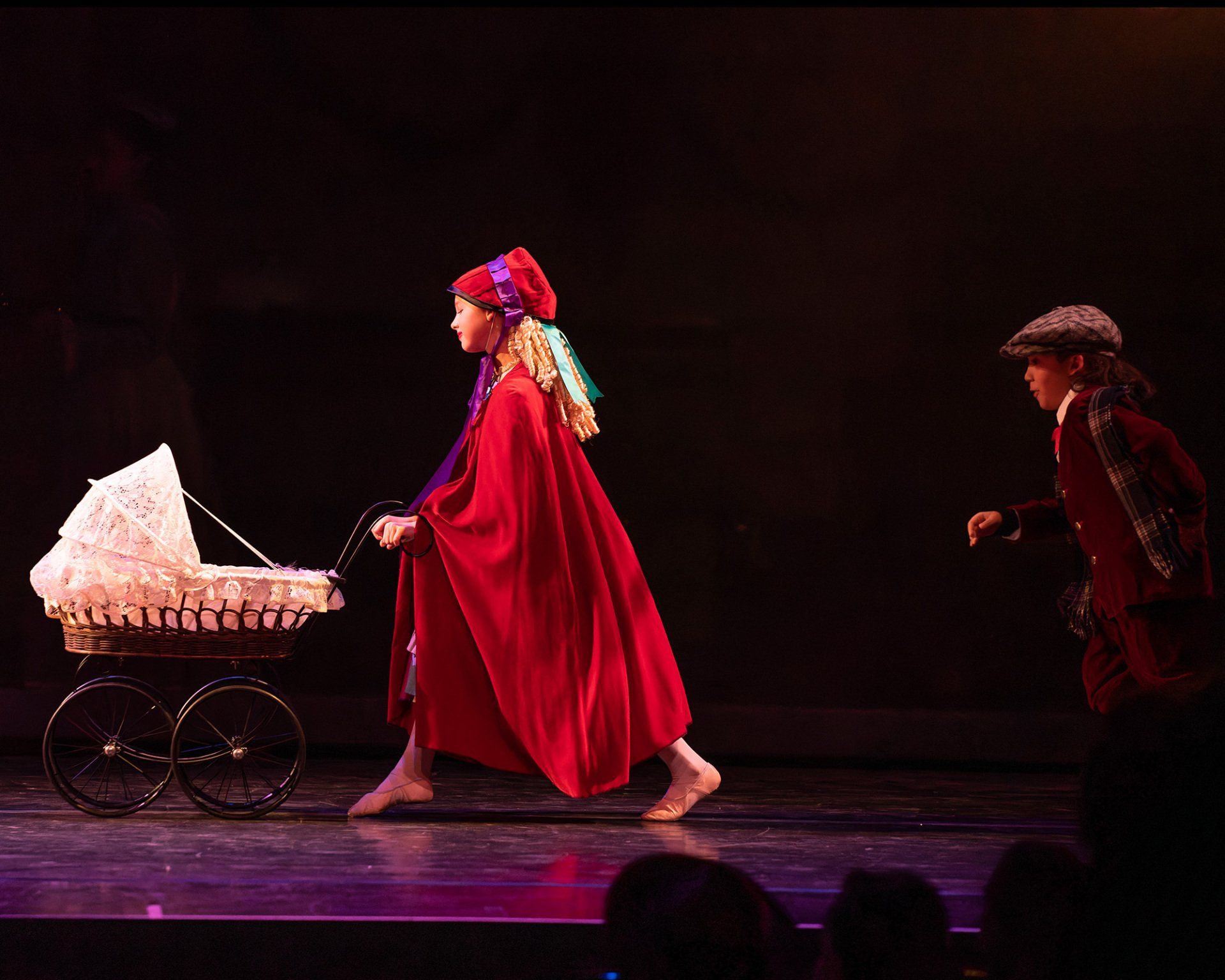 Dancers, one pushing a baby coach and another young male in tow