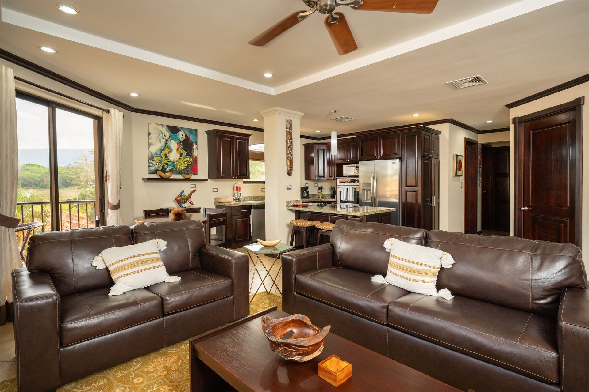 A living room with two couches , a coffee table and a ceiling fan.