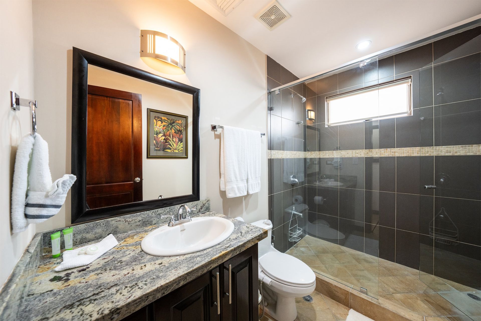 A bathroom with a sink , toilet and shower.