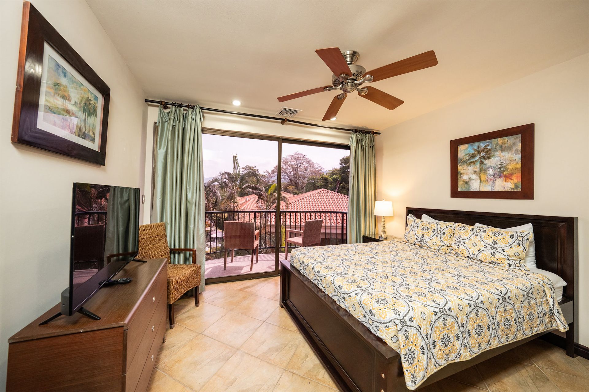 A bedroom with a king size bed and a ceiling fan