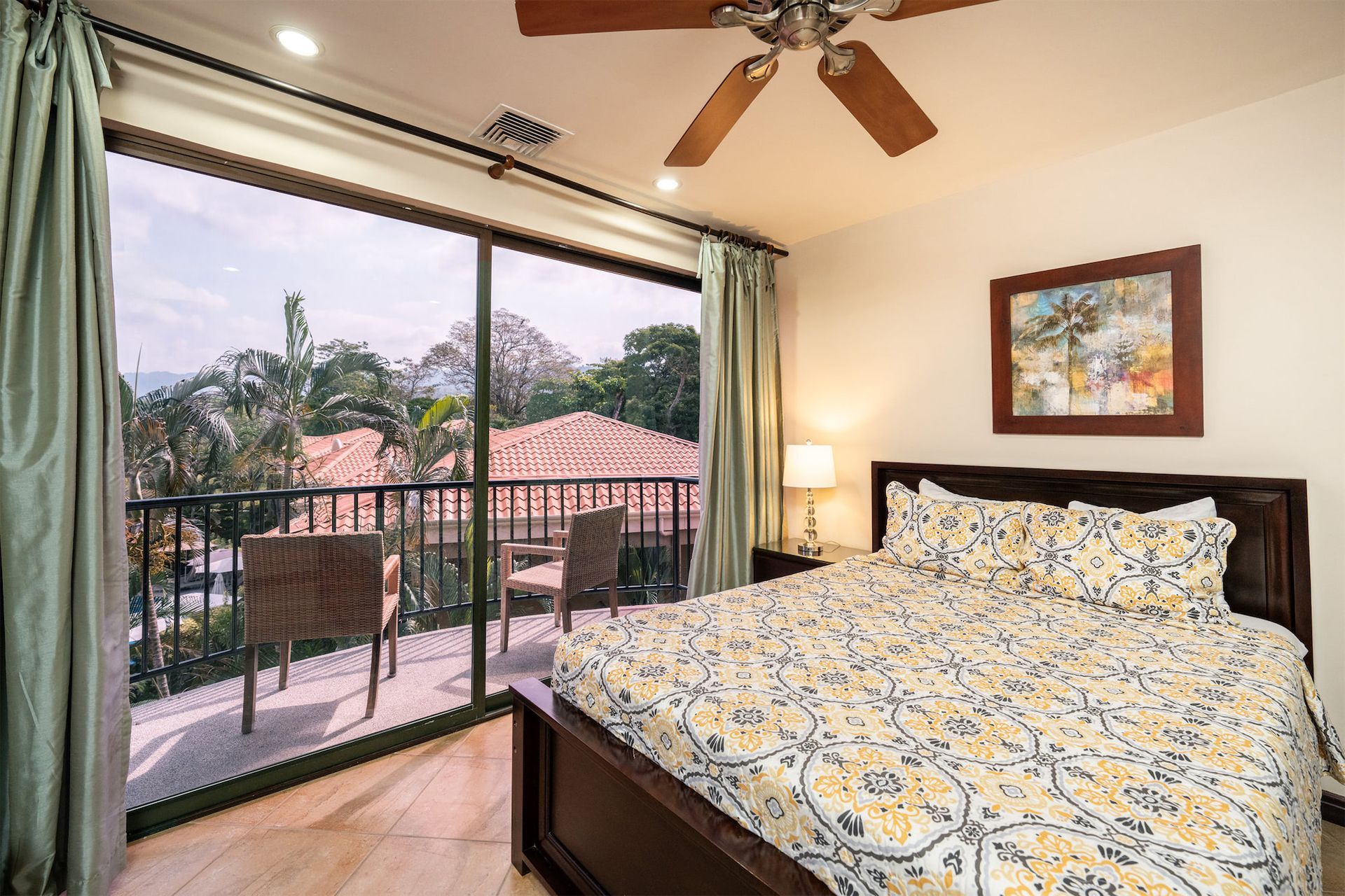 A bedroom with a large bed and a ceiling fan.