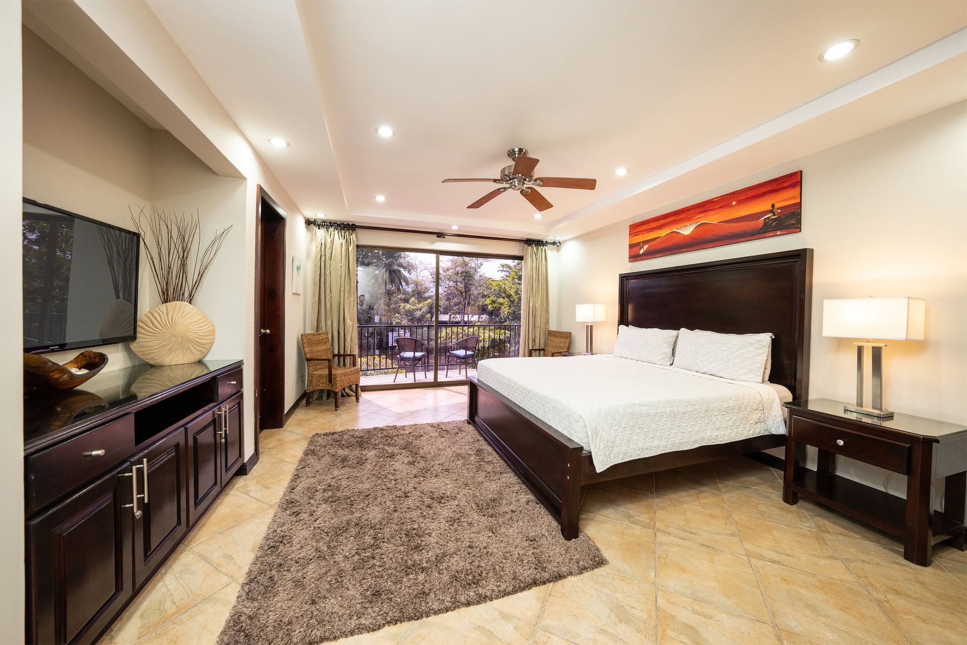 A bedroom with a large bed and a ceiling fan