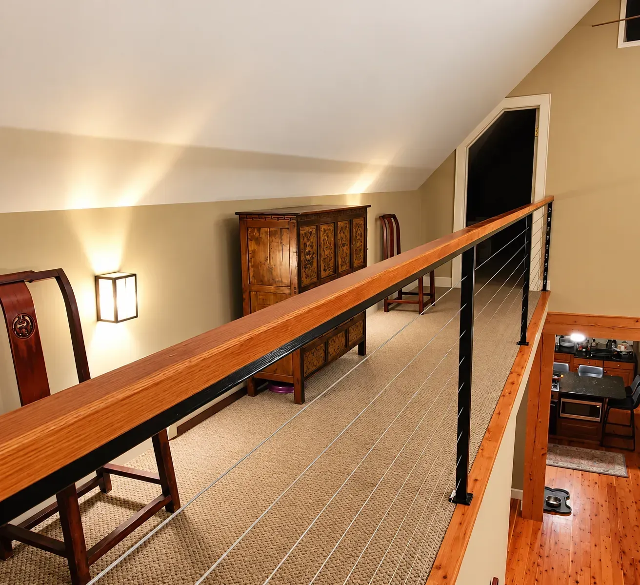 Loft walkway with interior cable railing and a wide wood cap