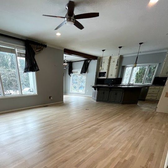 A living room with hardwood floors and a ceiling fan.