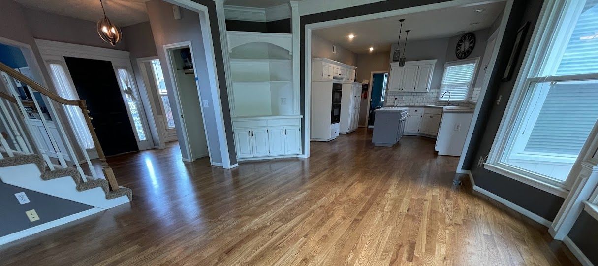 A living room with hardwood floors and stairs in a house.