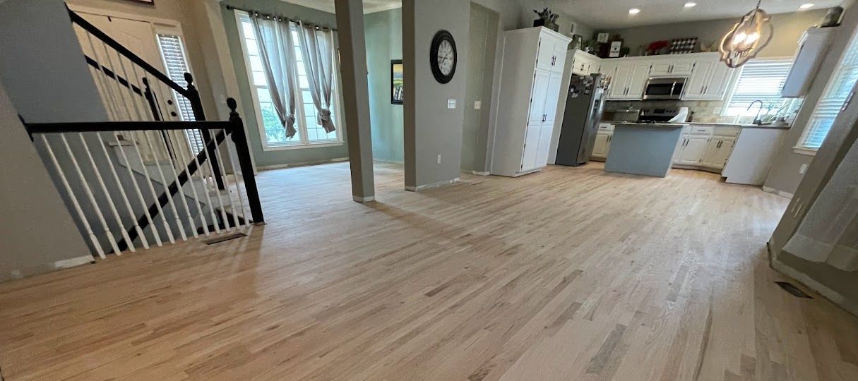 A living room with hardwood floors and a staircase in a house.