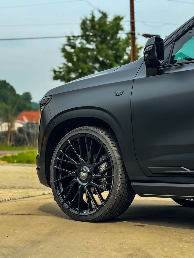 Black SUV with custom black wheels parked on concrete. Matte black finish.