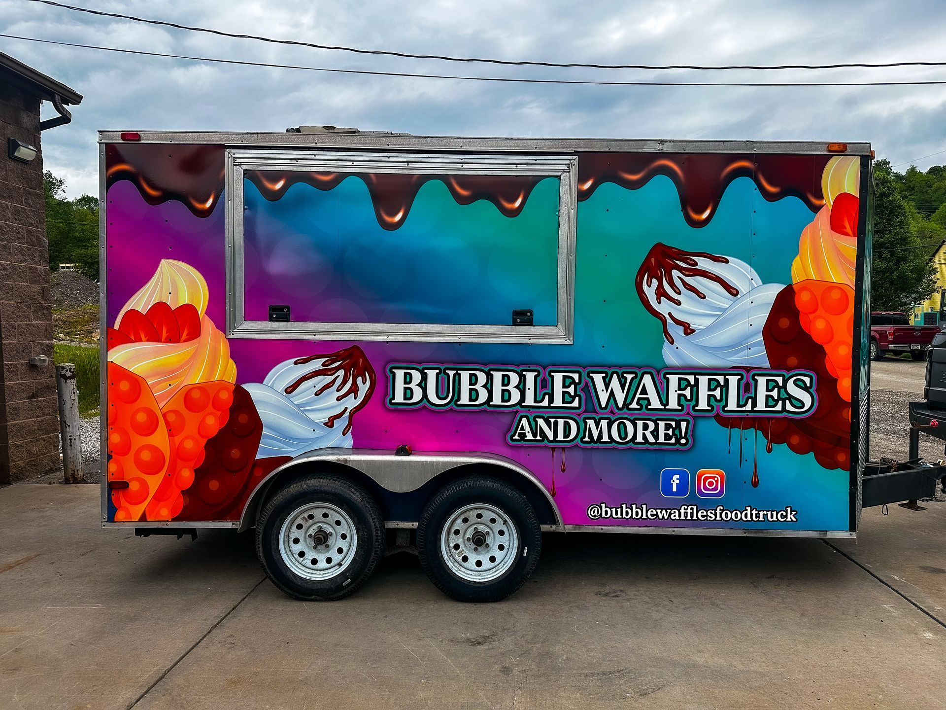 Food trailer with bubble waffles graphic, colorful exterior, white wheels, and text: