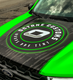 Truck hood with Octane Customs logo, green and black camouflage design.