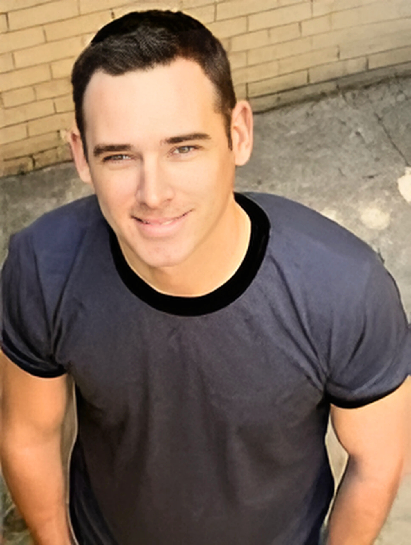 A man wearing a black t-shirt with a black collar
