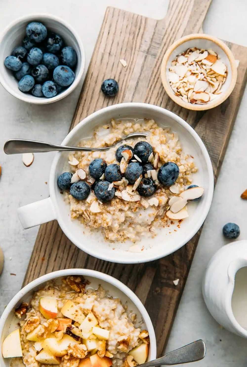 Three Bowls of Oatmeal With Blueberries and Almonds on a Wooden Cutting Board — Atherton Health Food Centre in Atherton, QLD