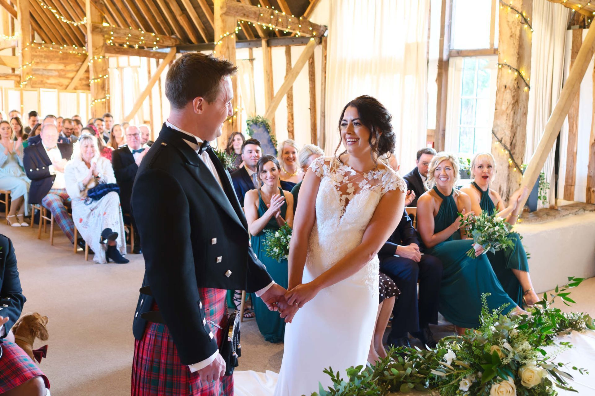 A bride and groom are holding hands during their wedding ceremony.