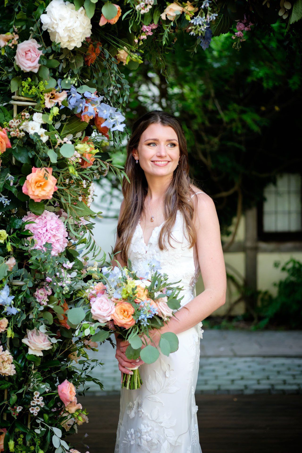 A bride in a white dress is holding a bouquet of flowers.