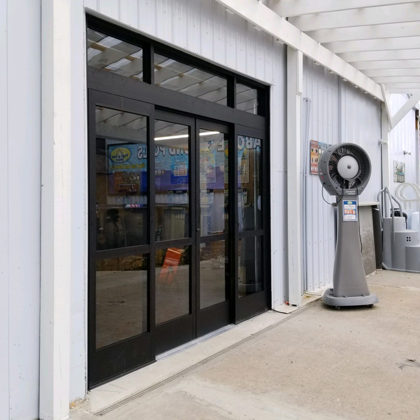 Automatic Doors Installation and Repair - A building with a sliding glass door and a fan in front of it