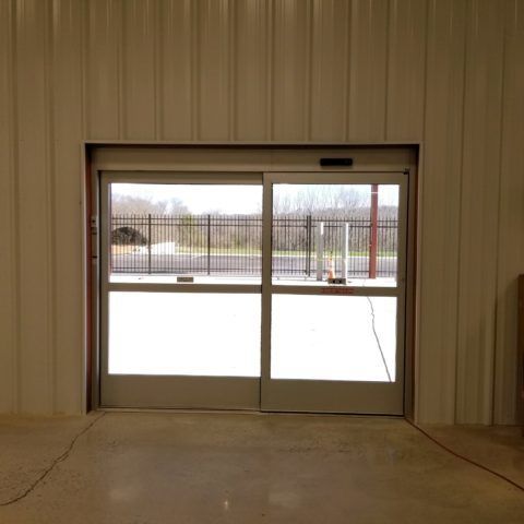 A sliding glass door in a building with a fence in the background.
