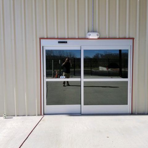Automatic Doors Installation and Repair - A reflection of a person in a sliding glass door