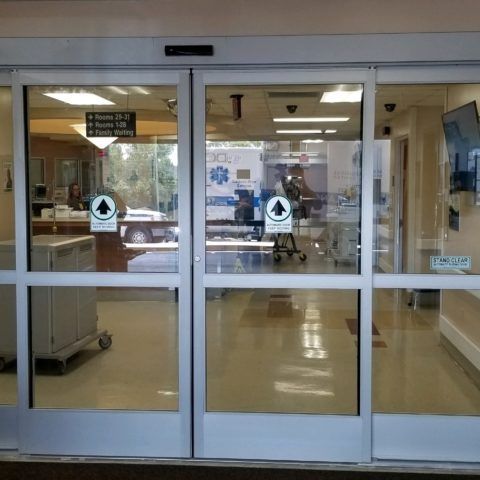 Automatic Doors Installation and Repair - An ambulance is reflected in the glass doors of a hospital