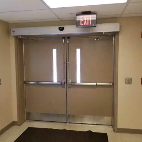 Automatic Doors Installation and Repair - An exit sign is above a pair of doors