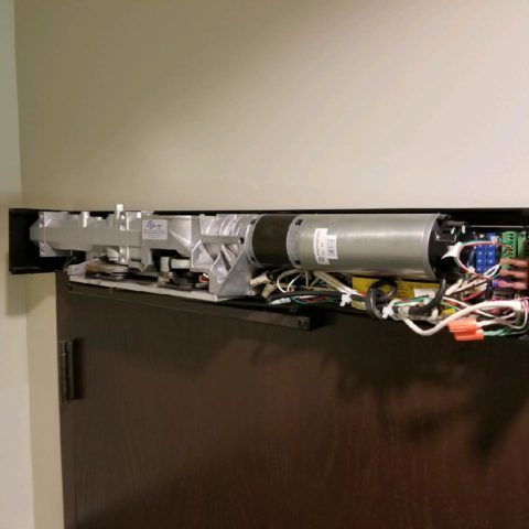 The inside of a door with a motor and wires.