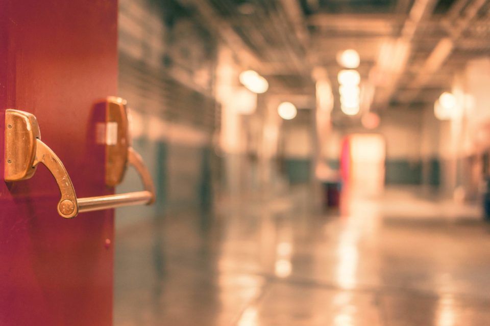 Exit Devices & Locking Hardware Installation and Repair - A red door with a handle in a hallway.