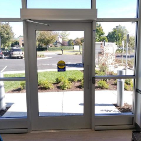 Storefronts & Glass Doors Installation and Repair - A door with a sticker on it that says emergency exit