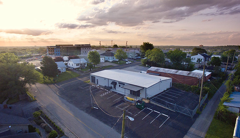 An aerial view of a small town at sunset with a parking lot in the foreground. An aerial view of a small town at sunset with a parking lot in the foreground.