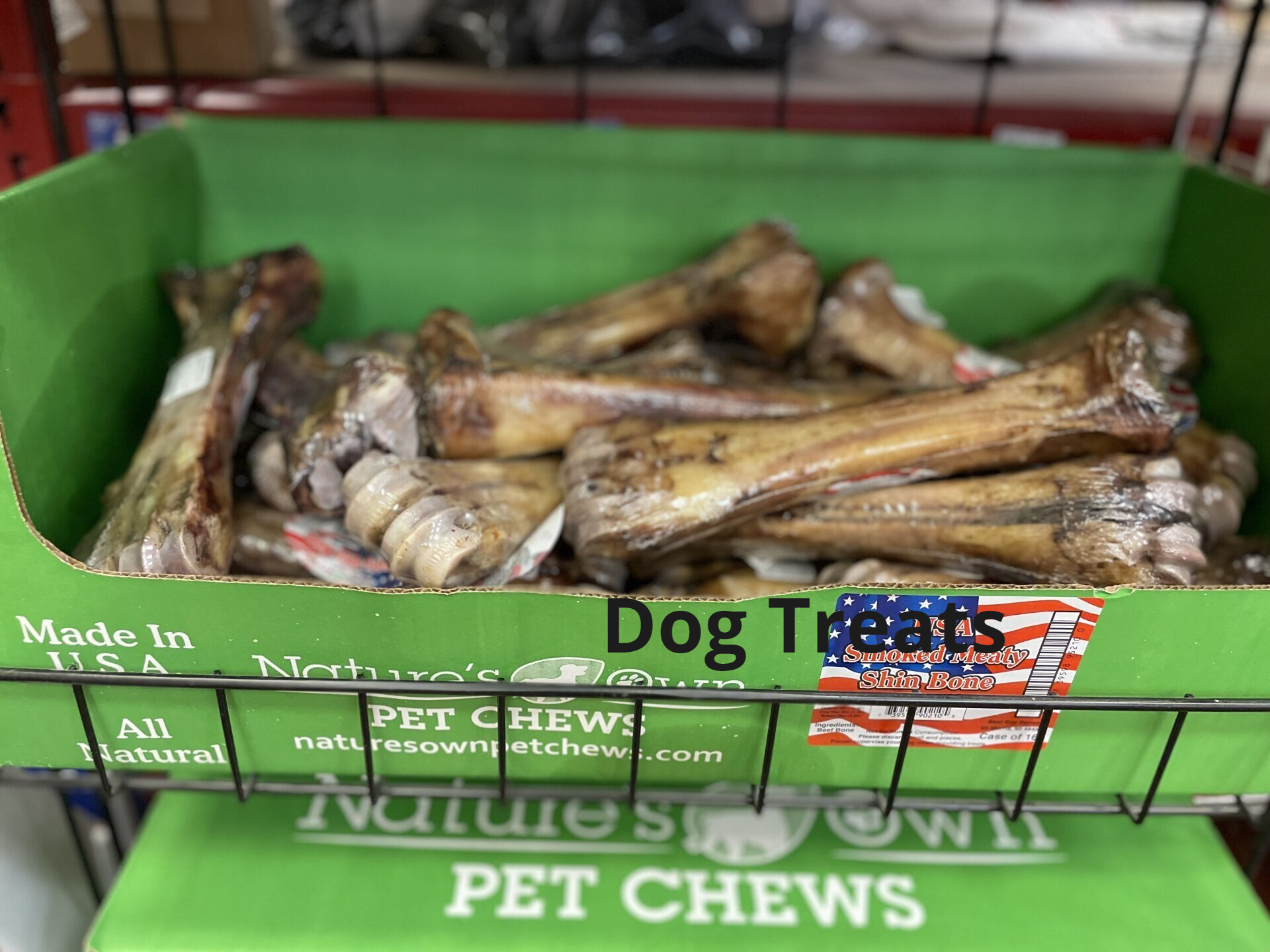 A box of dog treats is sitting on top of a green box.