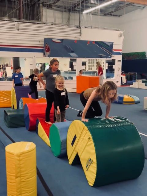 Children climbing colorful foam obstacles in an indoor gym