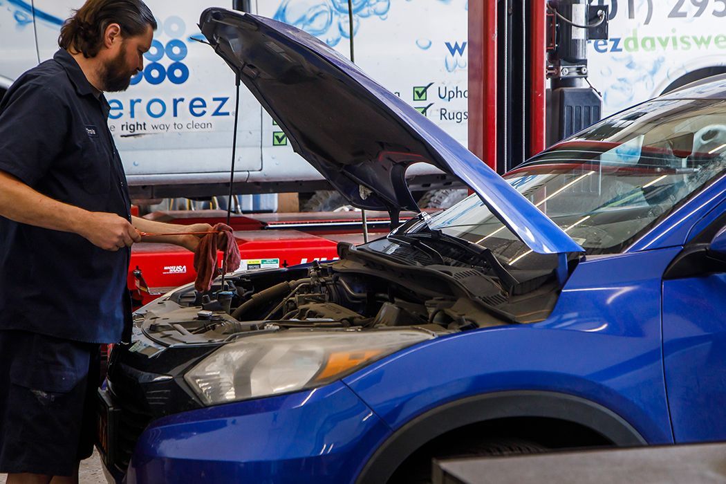 Our expert technician repairing a blue vehicle in our garage in Centerville, UT | Baker Automotive