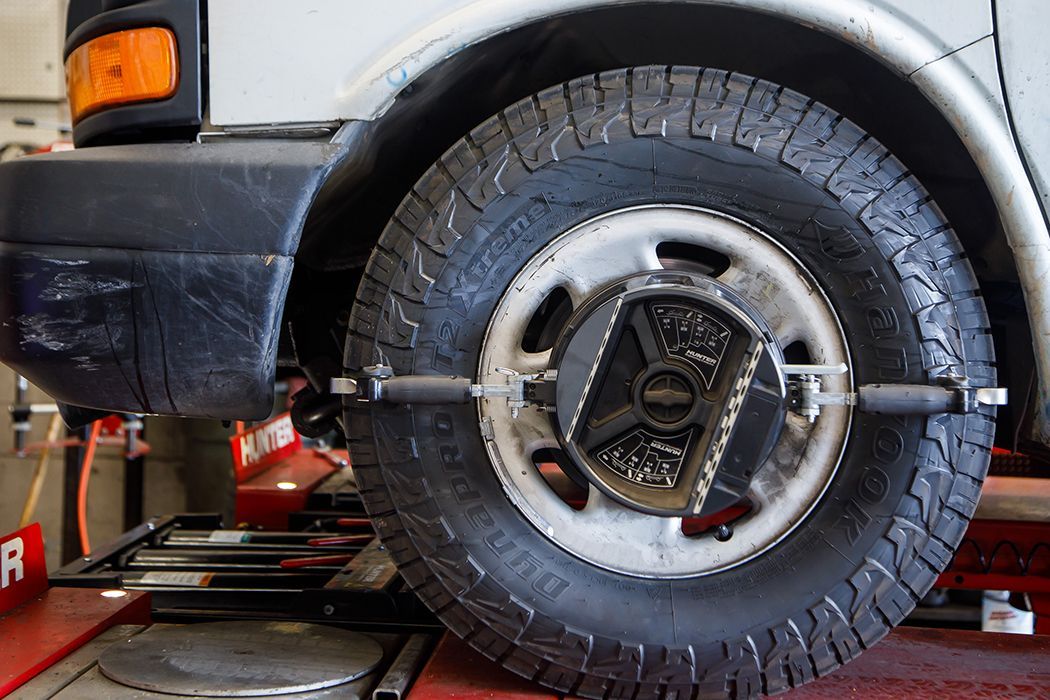 White truck with alignment tool on tire in our garage in Centerville, UT | Baker Automotive