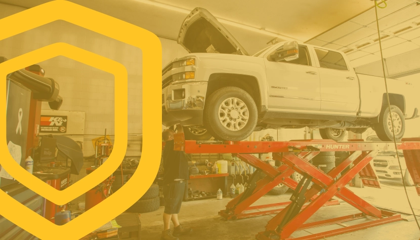 Reliable Coverage for Lasting Confidence, White truck lifted up in garage ready for expert repair | Baker Automotive