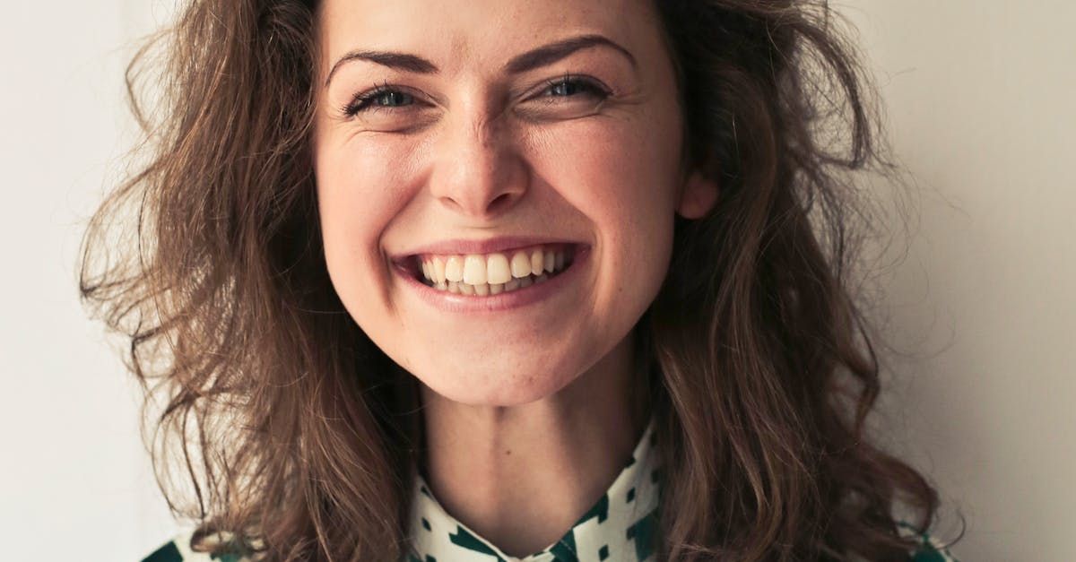 A close up of a woman smiling with her eyes closed.