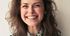 A close up of a woman smiling with her eyes closed.