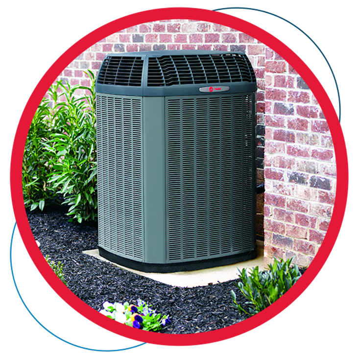 A large air conditioner is sitting outside of a brick building