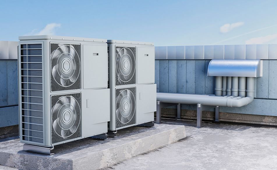 Two air conditioning units on a rooftop against a bright blue sky.