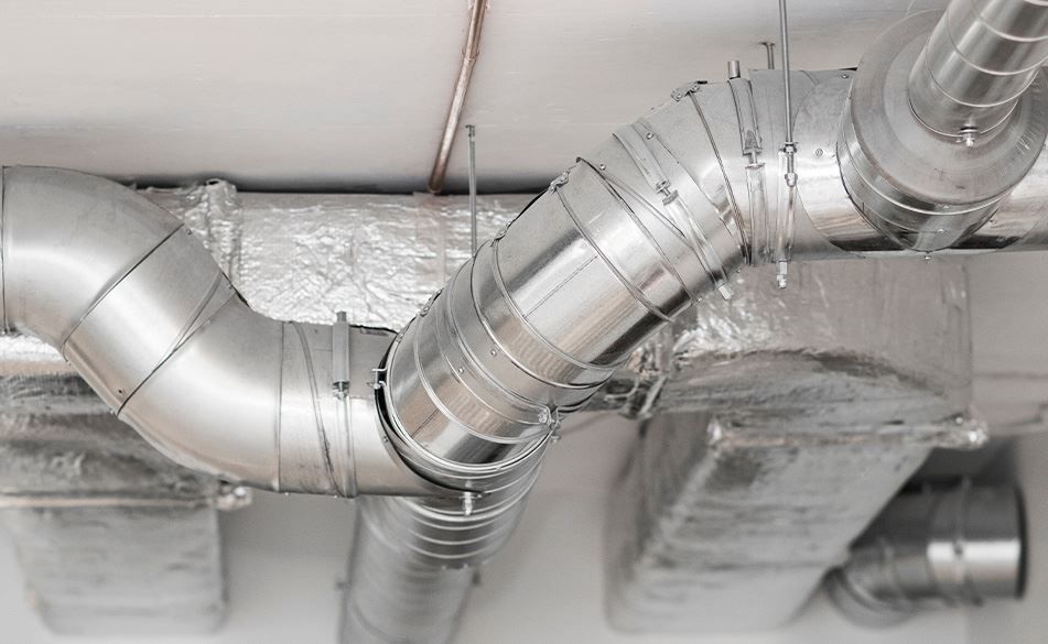 Silver HVAC ductwork, insulated, installed on a ceiling.