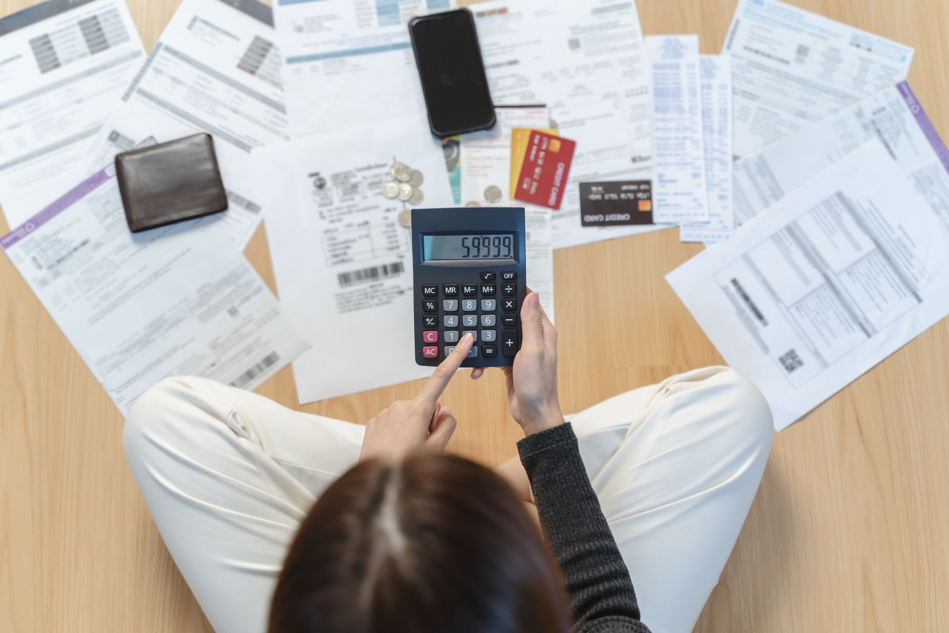 Person reviewing bills and cards for debt consolidation.