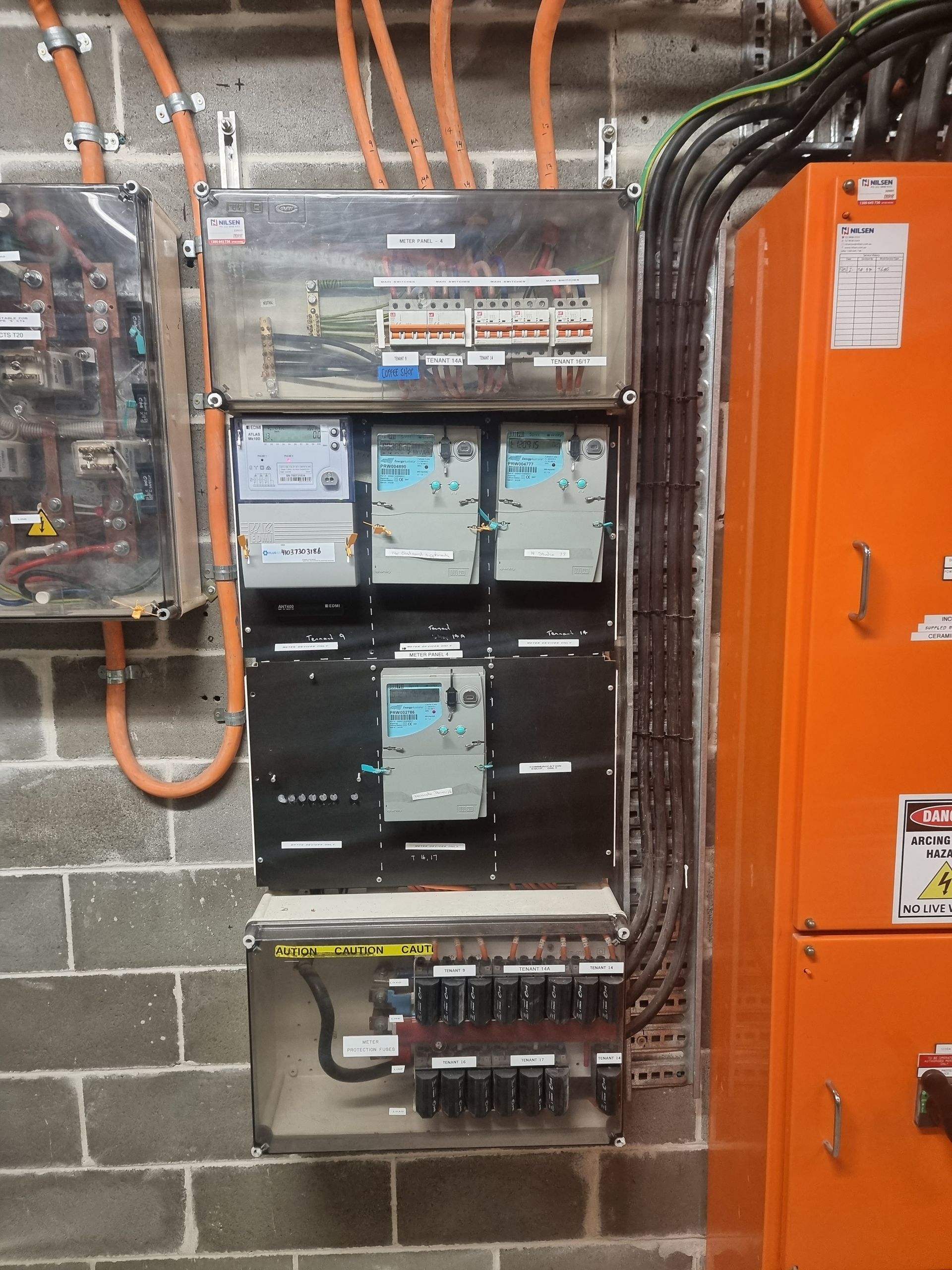 Open electrical panel with circuit breakers and colored wiring inside a metal box