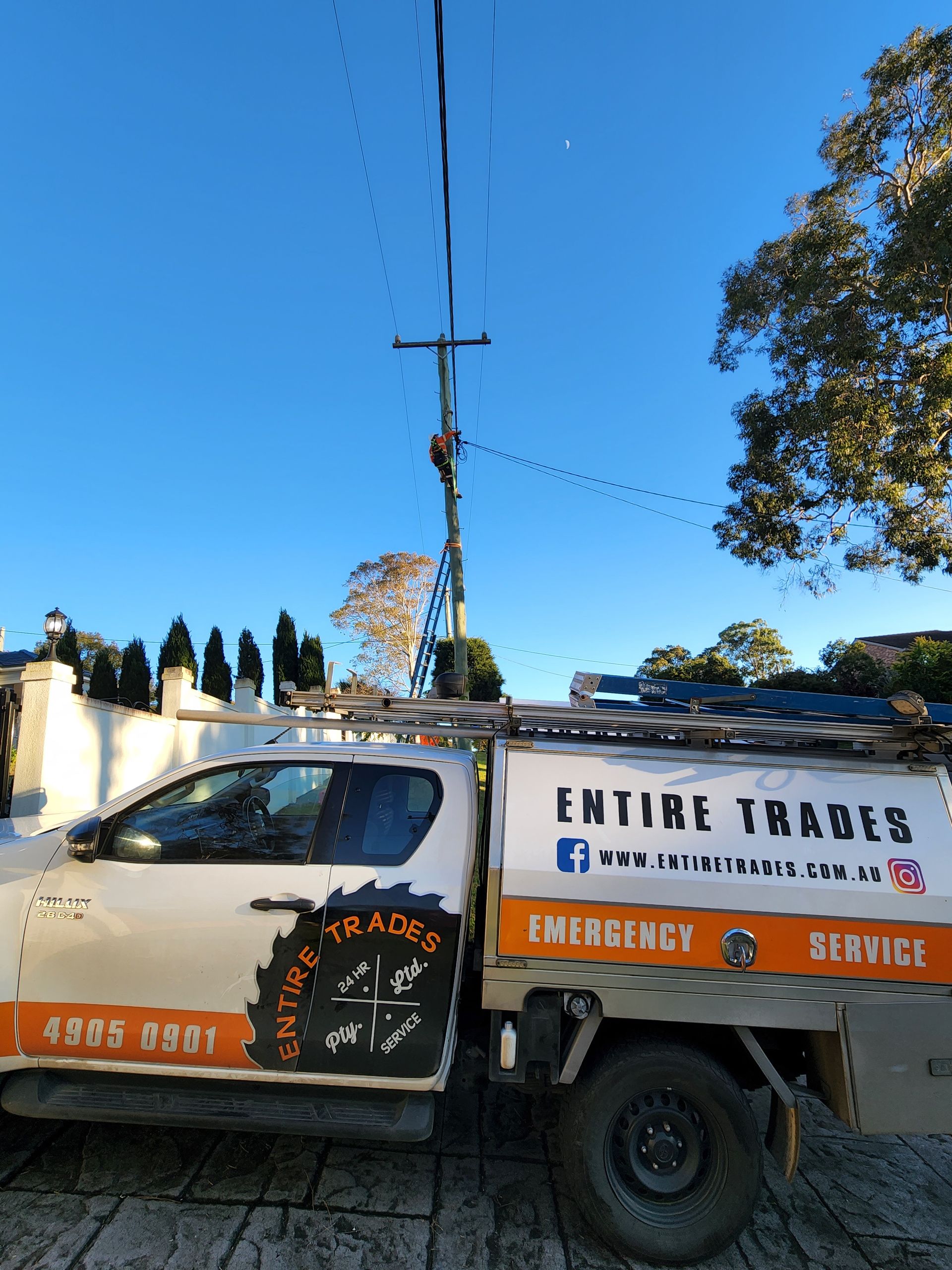 White service truck parked at a loading dock beside a building, with company logos on the side.
