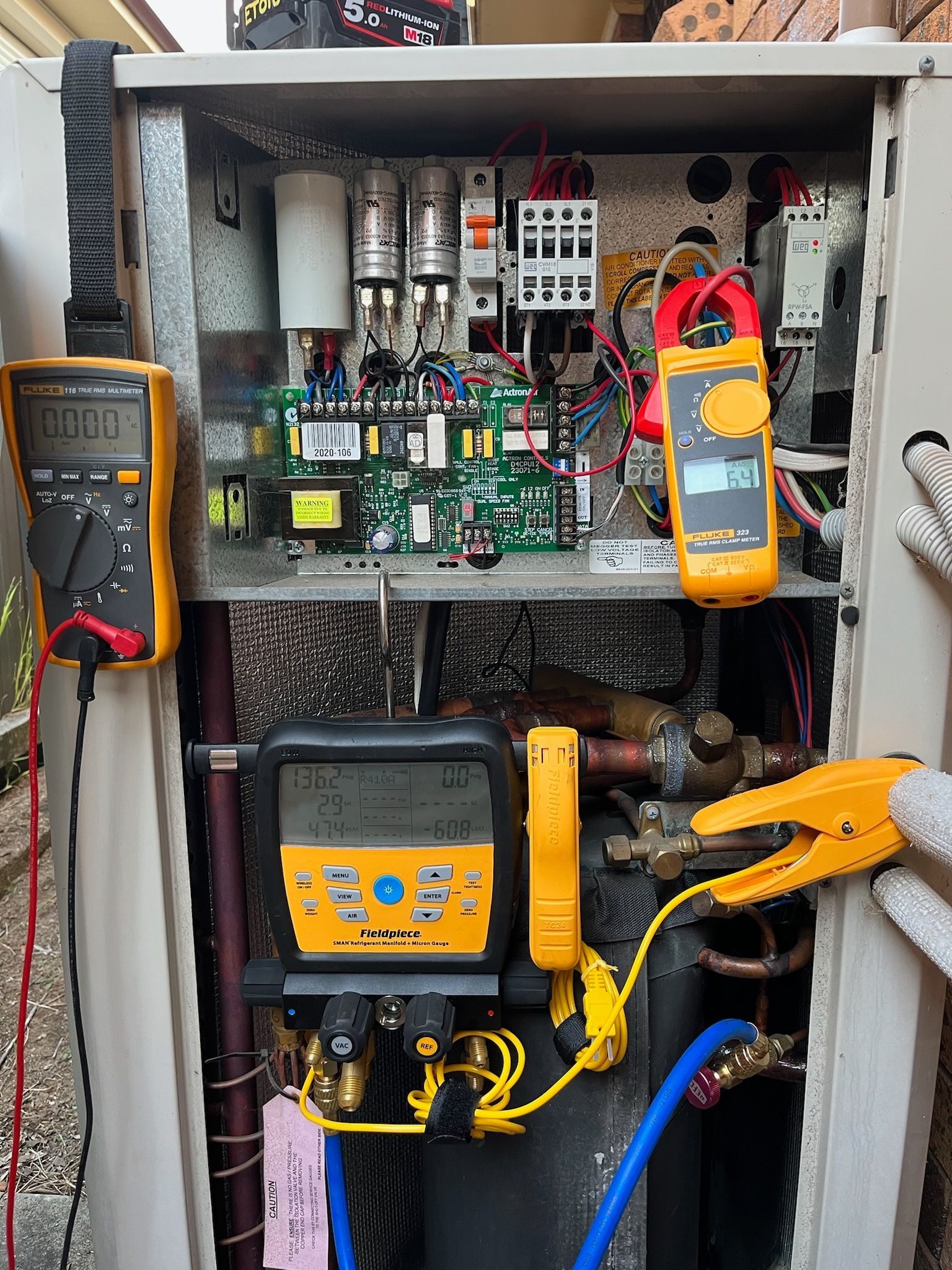 Open electrical panel with circuit breakers and colored wiring inside a metal box