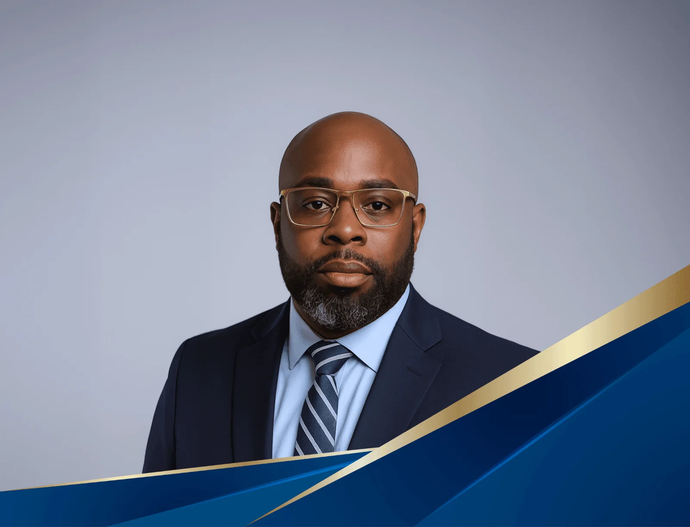 Formal headshot of a man in a navy suit and striped tie against a light gray background with blue and gold accents
