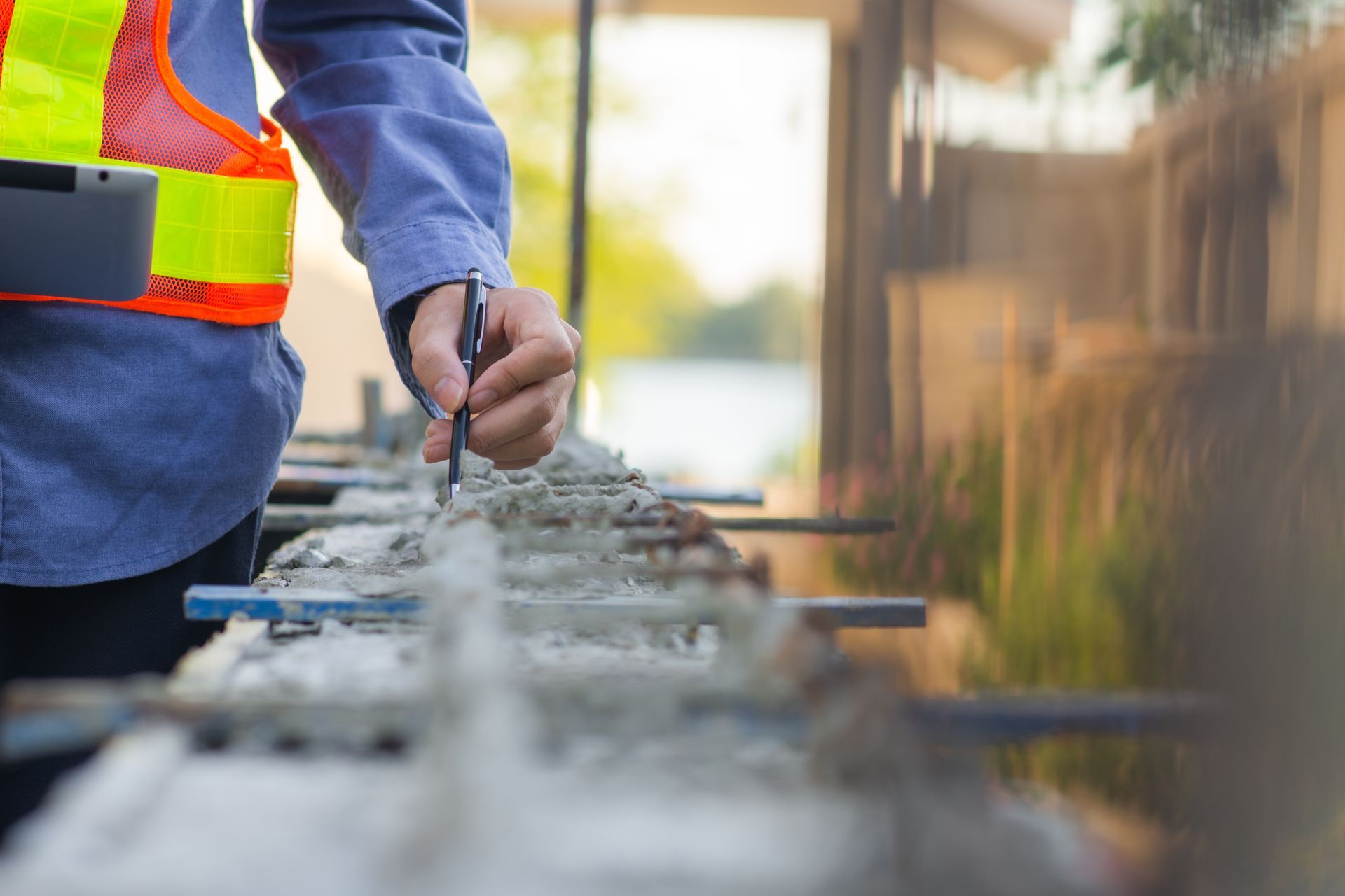 Construction worker smoothing wet concrete with a trowel at a worksite