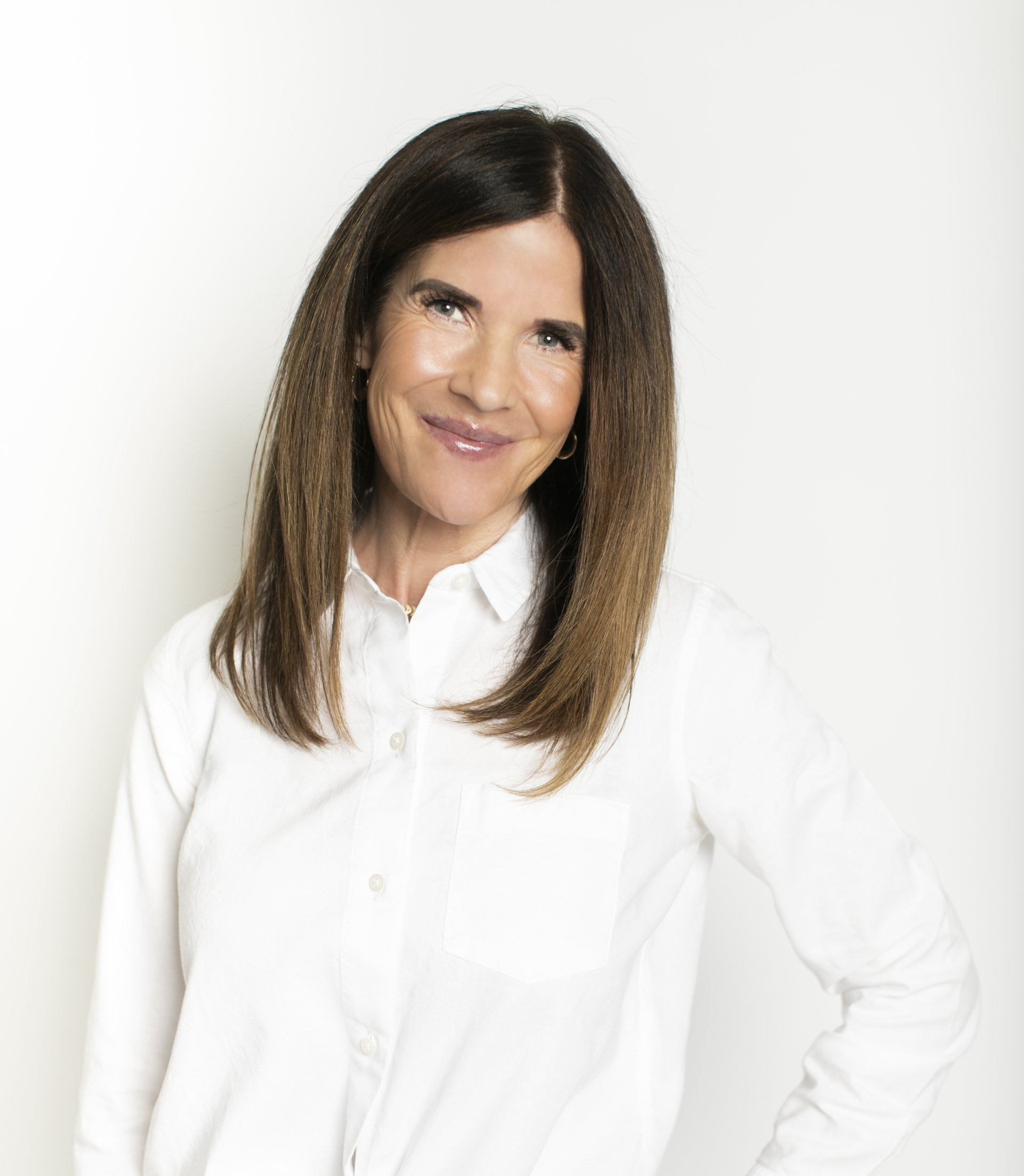 Smiling person in a white shirt against a plain light background