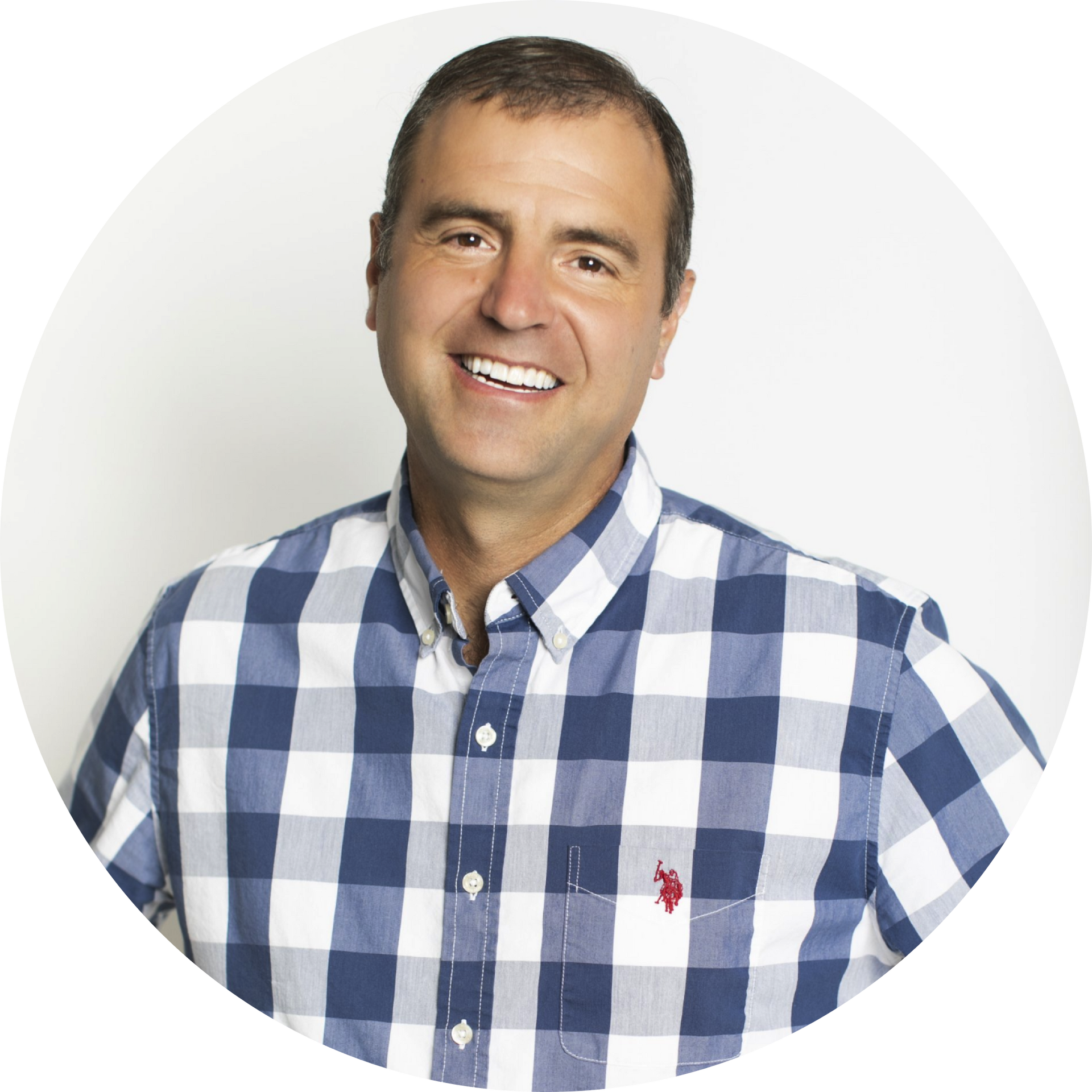 Smiling man in a blue-and-white plaid shirt against a light gray background