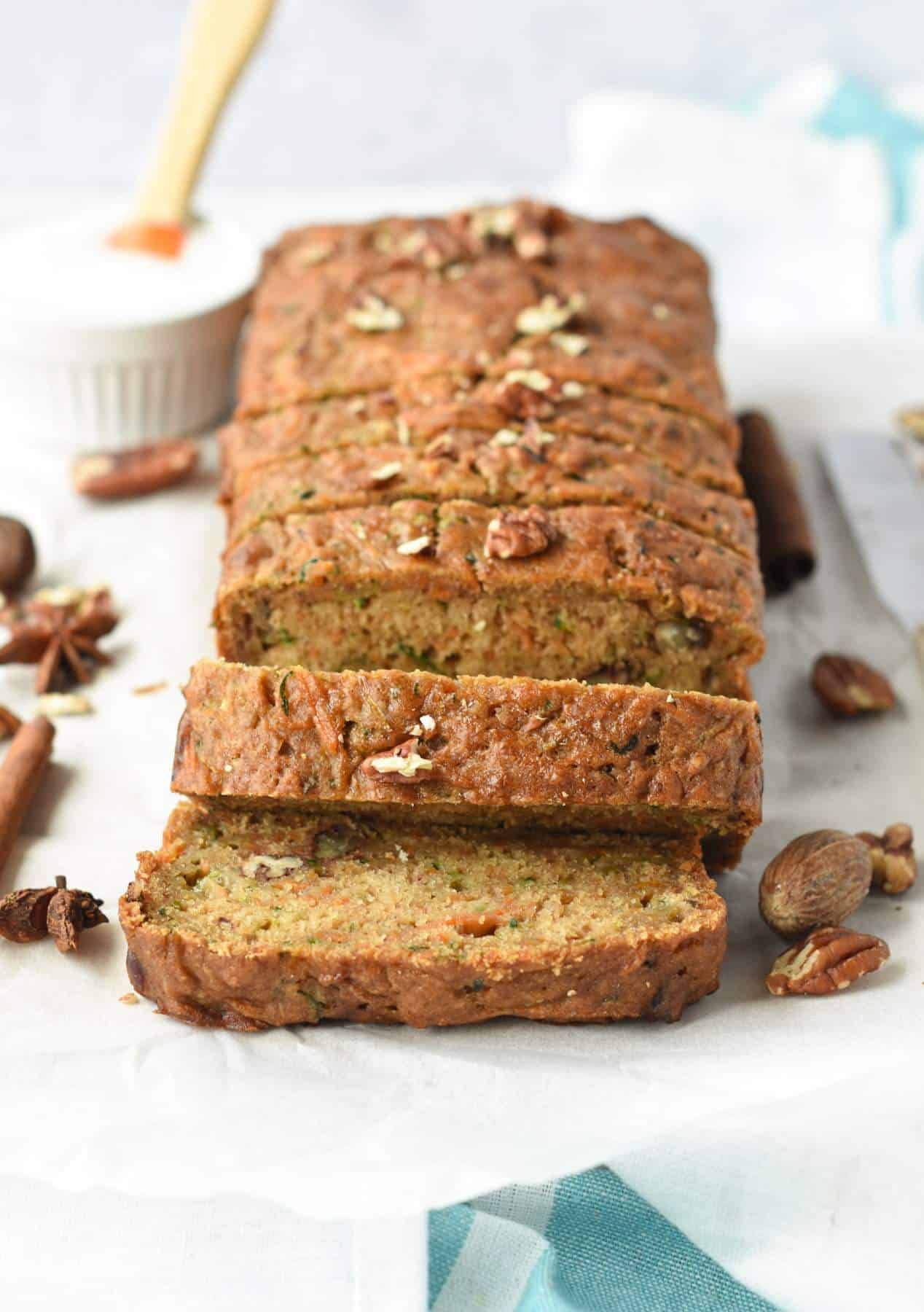 A loaf of banana bread is cut into slices and sitting on a table.