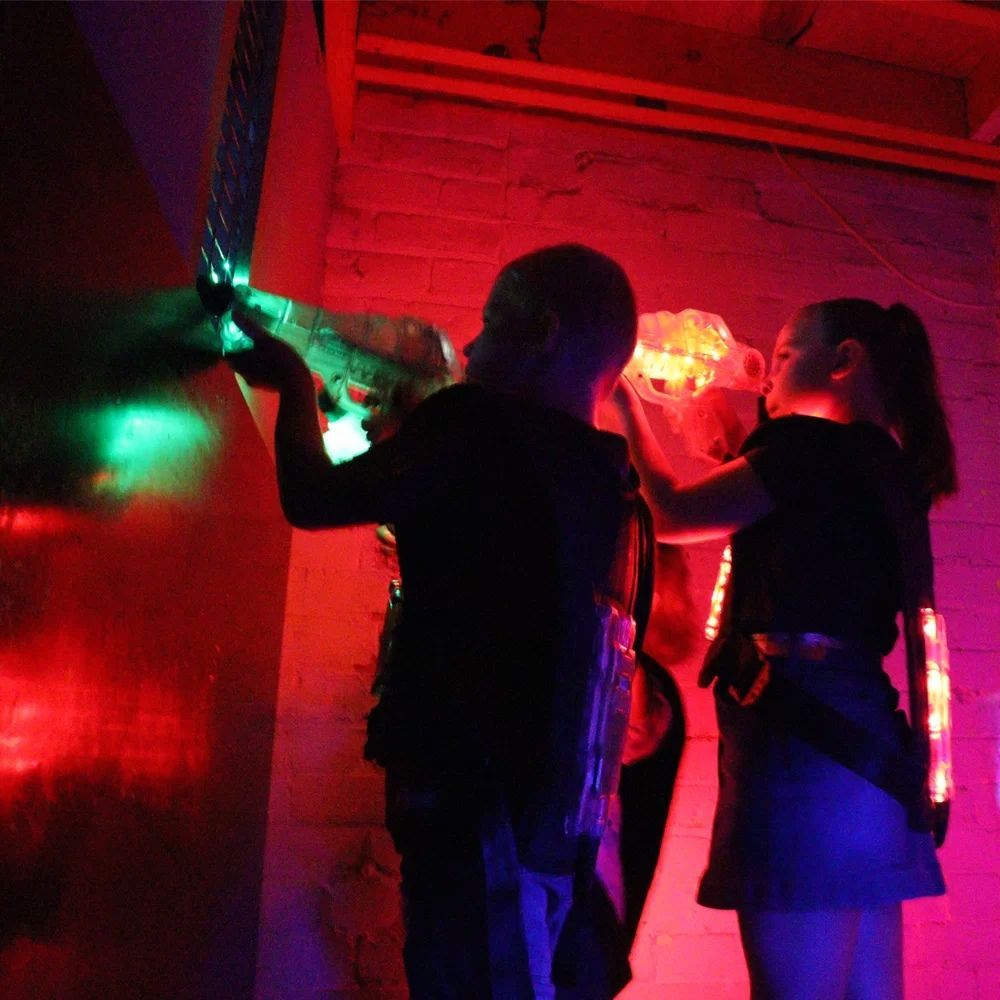 A Man And A Woman Are Standing Next To Each Other In A Dark Room In A Game Of Laser Tag — Laser Tag Wagga In Wagga Wagga, NSW