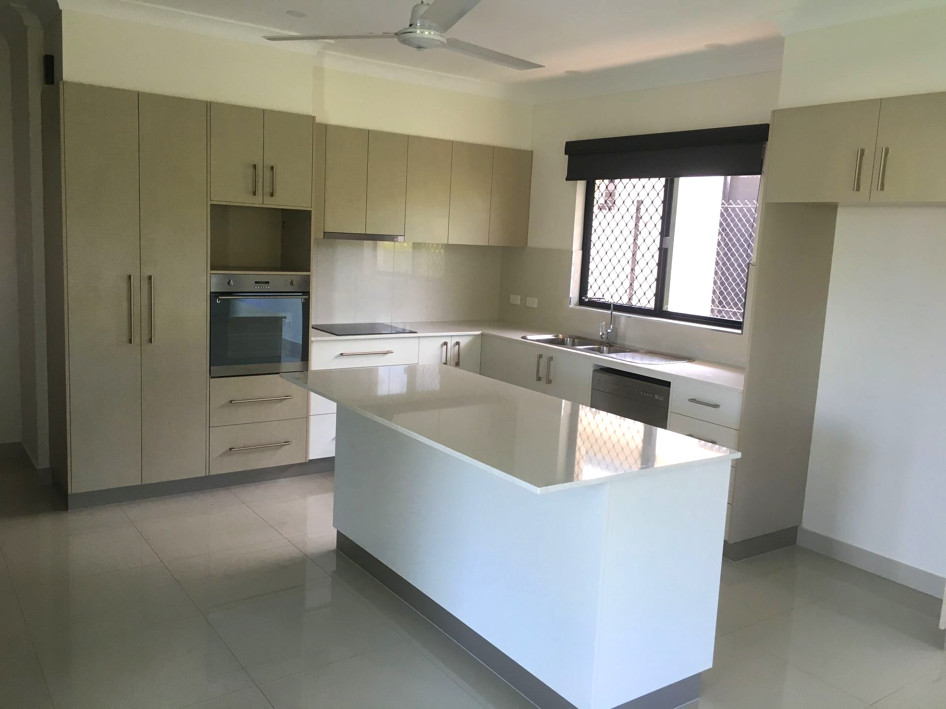 Modern kitchen with light-coloured cabinets, white island, and stainless steel appliances — AKW Builders Pty Ltd In Leanyer, NT