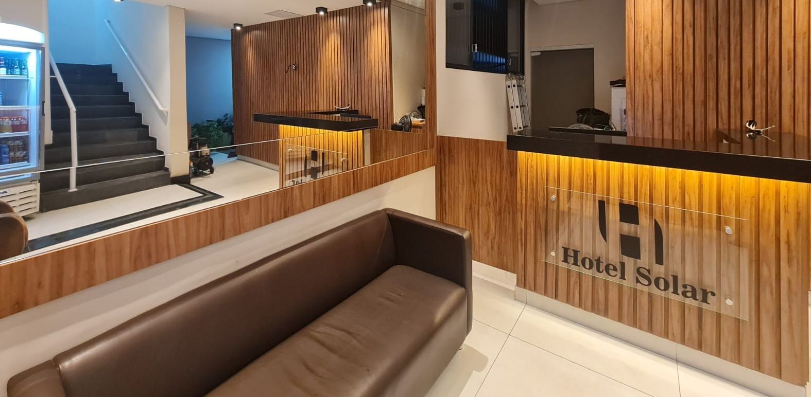 Um lobby de hotel com um sofá e um balcão. - Hotel Solar Bela Vista