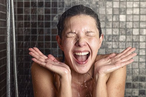 A woman shocked by cold water during her shower